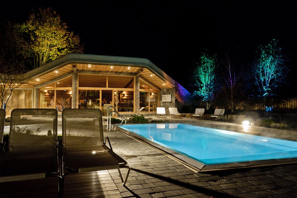 Nachtstimmung mit beleuchtetem Finlantis-Pool und Blick auf Panorama-Sauna